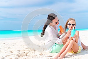 Young mother applying sun cream to daughter nose on the beach. The concept of protection from ultraviolet radiation