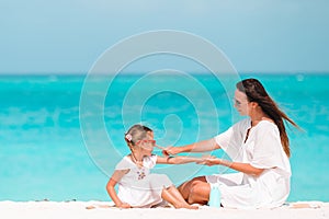 Young mother applying sun cream to daughter nose on the beach. Sun protection