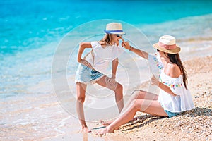 Young mother applying sun cream to daughter nose on the beach. Sun protection