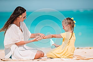 Young mother applying sun cream to daughter nose on the beach. Sun protection