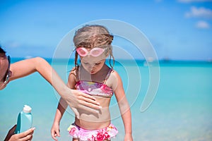 Young mother applying sunblock cream on her