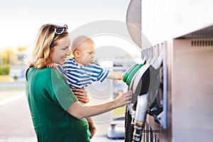 Young mother with baby boy at the petrol station.