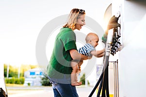 Young mother with baby boy at the petrol station.