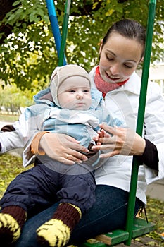 Young mother and baby boy on swing