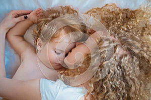 Young mother and baby child sleeping together. Dreams and kids sleep.