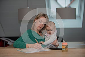 Young mother with baby child working at home