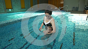 Young mother with baby in the pool