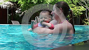 Young mother with a baby in the pool.