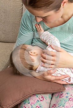 Young mother breast feeding her baby at home