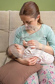 Young mother breast feeding her baby at home