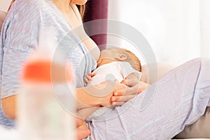 Young mother breastfeed newborn baby with breast photo