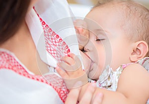 Young mother breastfeeds her baby.