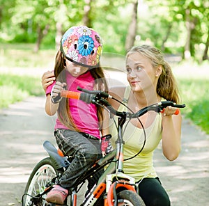Young mother calms the sad daughter who did not get to ride a bike