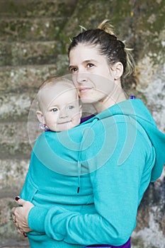 Young mother carrying her baby in sling