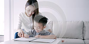 Young mother checking homework helping child with study at home