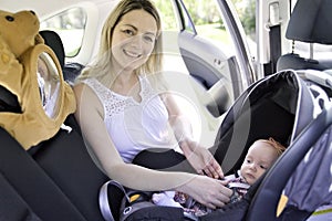 A Young mother and child in car. Baby seat on chair. Safety driving concept.
