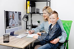 Young mother and child enjoying digital era, having online telemedicine consultation with remote doctor by professional