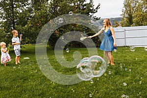 Young Mother and children blowing soap bubbles