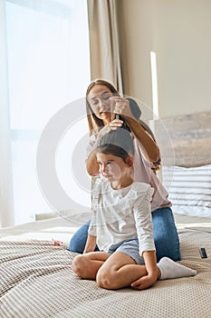 Young mother combing kid
