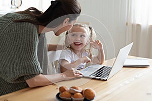 Young mother controlling little kid computer usage.