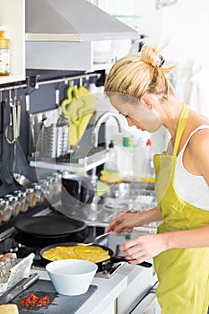 Young Mother Cooking at Home.