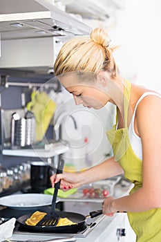 Young Mother Cooking at Home.