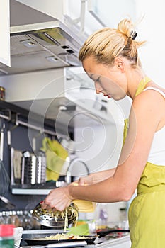 Young Mother Cooking at Home.