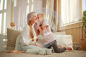 Young mother with daughter child play fun at home in bed, happy leisure lifestyle