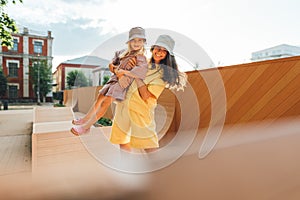 Young mother and daughter having fun outdoor at sunset