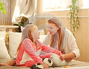 Young mother and daughter are having fun playing at home, happy parenting and family leisure