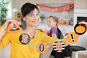 young mother with young daughter preparing for halloween