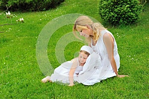 Young mother and daughter resting in meadow