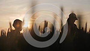 Young mother farmer teaches her daughter to work in a wheat field. Silhouette of a farmers family in a wheat field at