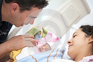 Young mother and father with their newborn baby girl at the hospital on the day of her birth. Family concept. Parenthood concept