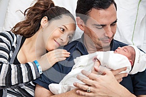 Young mother and father with their newborn baby girl at the hospital on the day of her birth. Family concept. Parenthood concept