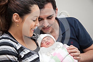 Young mother and father with their newborn baby girl at the hospital on the day of her birth. Family concept. Parenthood concept