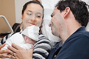 Young mother and father with their newborn baby girl at the hospital on the day of her birth. Family concept. Parenthood concept