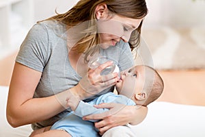 Young mother feeding her adorable baby