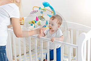 Young mother feeding her baby with porridge in bed