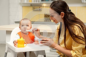 Young mother feeding her little baby