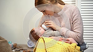 Young mother feeding infant from bottle, problems with breast feeding, mastitis photo