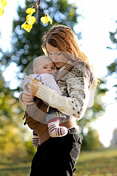 Young mother with her baby in a carrier