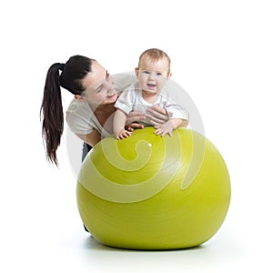 Young mother and her baby child doing yoga exercises on gymnastic ball isolated over white