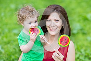 Young mother and her baby daughter eating candys