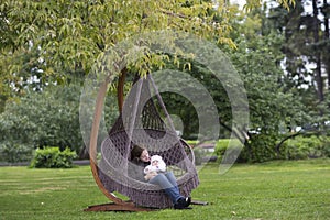 Young mother and her baby daughter in hammock