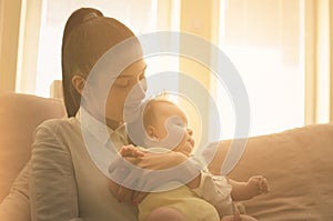 Young mother with her baby girl at home.