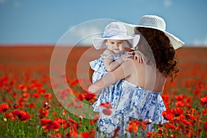 Young mother and her baby-girl in poppy field