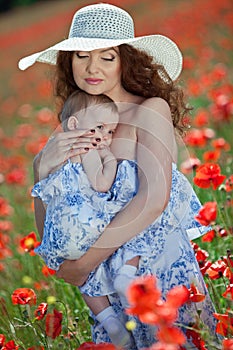 Young mother and her baby-girl in poppy field