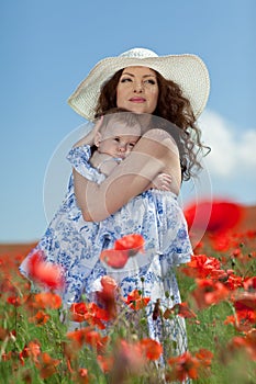 Young mother and her baby-girl in poppy field