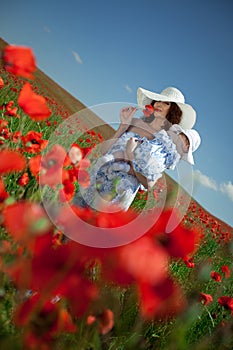 Young mother and her baby-girl in poppy field